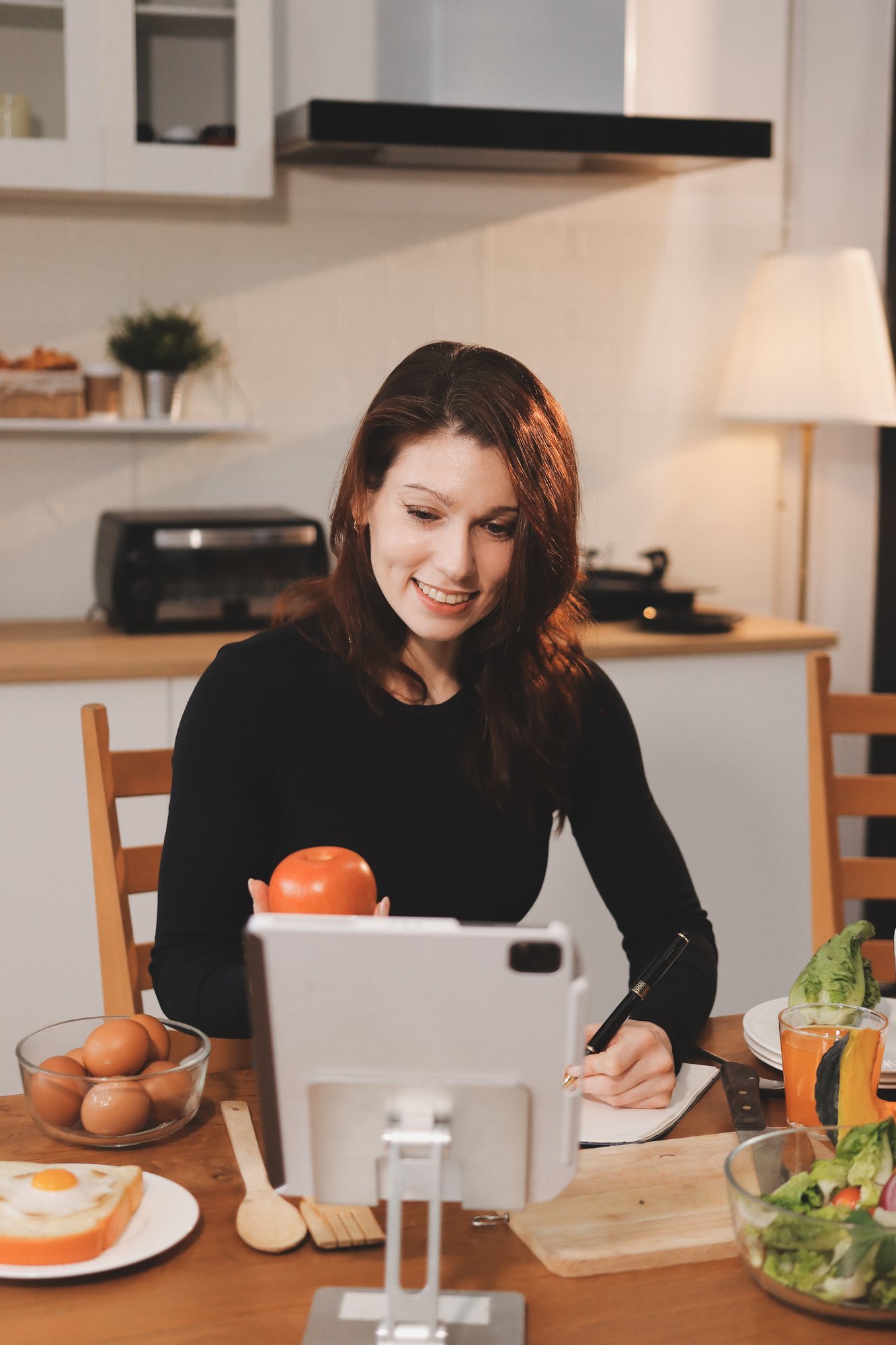 Student cooking at home with instructor on screen